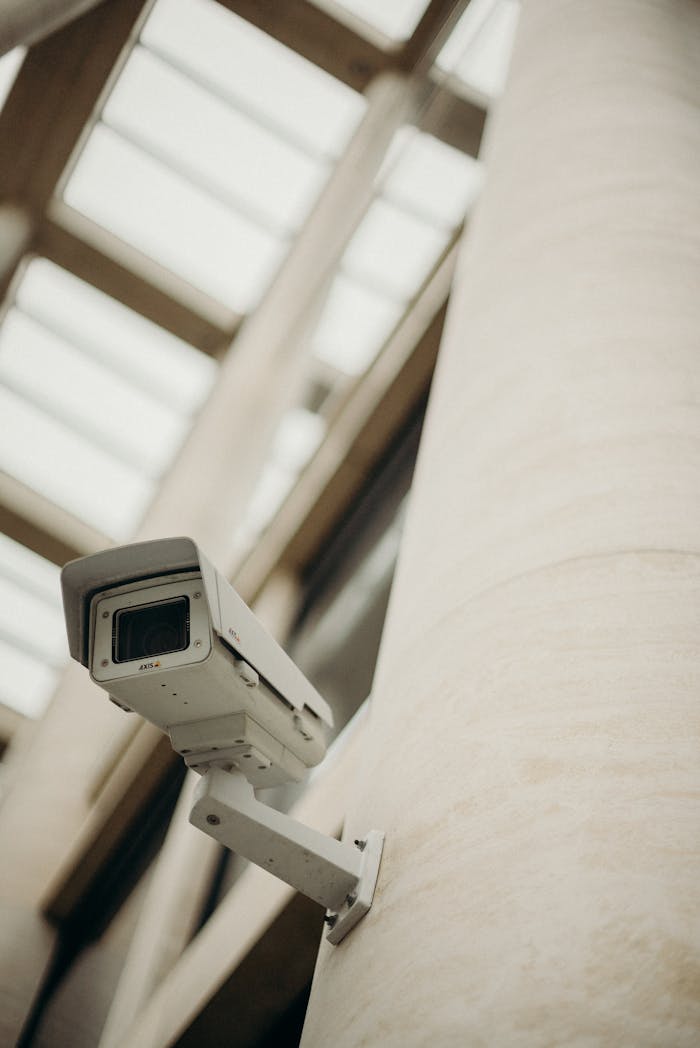 Mastering the First Impression: Your intriguing post title goes here Close-up of a security camera on a building wall, showcasing surveillance technology.